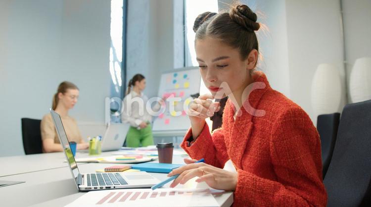 資料を見ている女性と打ち合わせする同僚 ビジネス,ビジネスマン,ビジネスウーマンの写真素材