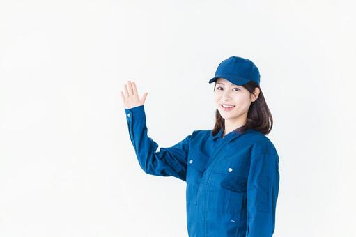 作業服を着て笑顔でご紹介をする若い女性 作業服を着て笑顔でご紹介をする若い女性 仕事,指す,物流の写真素材