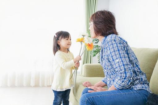 祖母に花をあげる子ども 祖母に花をあげる子ども 可愛い,家族旅行,教育の写真素材
