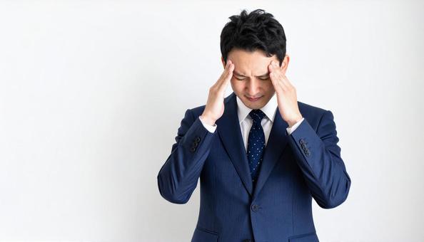 ストレスで顔をおおう日本人ビジネスマン ストレスで顔をおおう日本人ビジネスマンの写真