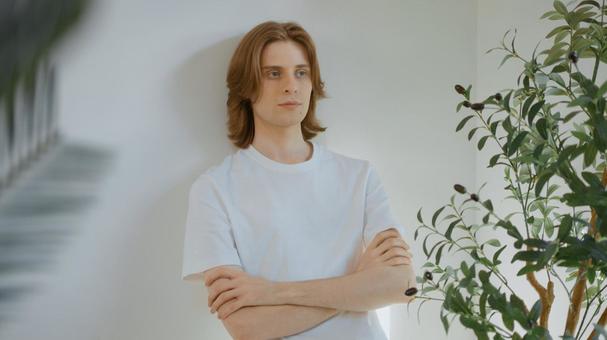 腕組みをして壁にもたれる白いTシャツを着た男性 男性,外国人,欧米人の写真素材