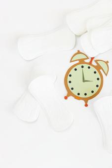 たくさんの生理用ナプキンと紙でできた時計 生理,月経,生理用品の写真素材