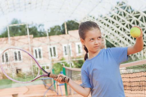 ラケットを振り上げる子供のプレーシーンの写真