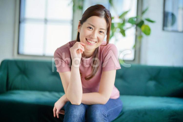 ソファーに座って頬杖をついている女性 女性,日本人,1人の写真素材