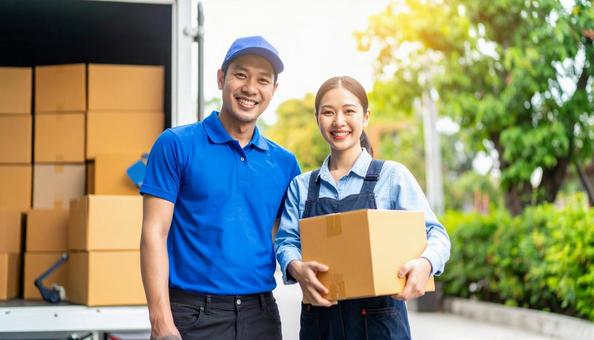 ダンボールを持つ運送業者の男女の写真