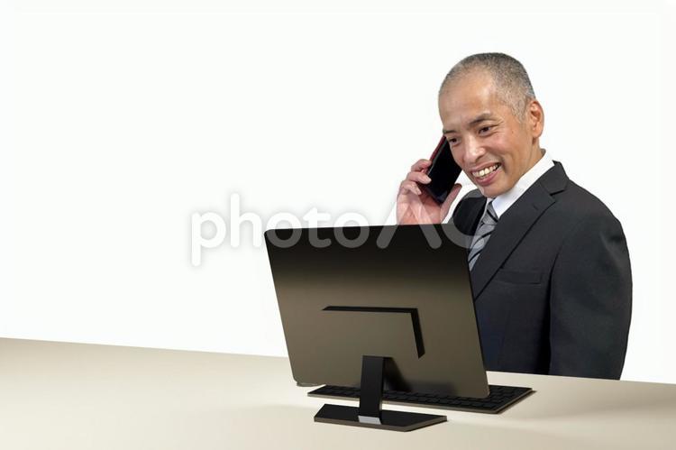 パソコンを見て電話するスーツの中年男性 電話,ビジネス,男性の写真素材