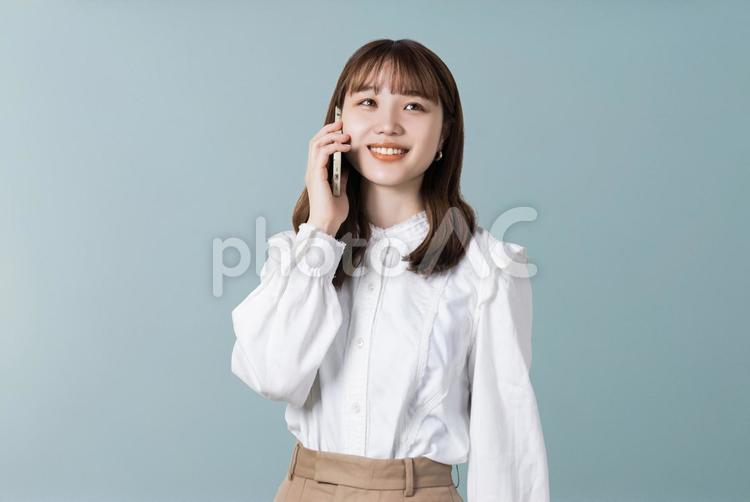 スマホで通話をする笑顔のビジネスウーマン 女性,ビジネス,スマホの写真素材
