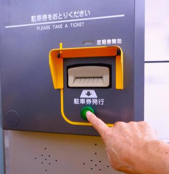駐車場の発券機(ボタン押し) 駐車場の発券機(ボタン押し) 駐車場,発券機,車の写真素材
