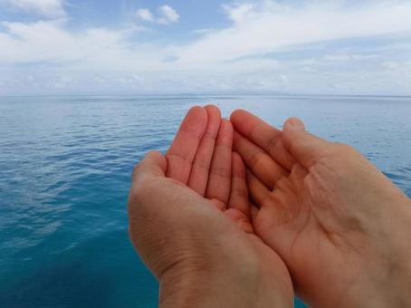 海がもたらす恵みを受け取るハンドサインの写真