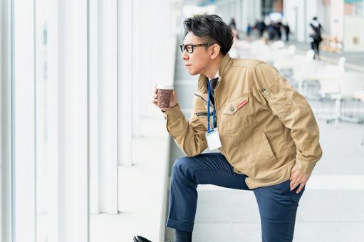 決め顔でドリンクを飲む作業服の男性 決め顔でドリンクを飲む作業服の男性 ビジネス,ビジネスマン,作業員の写真素材