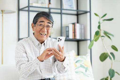 家でスマホを使うシニアの男性 家でスマホを使うシニアの男性 シニア,スマホ,男性の写真素材