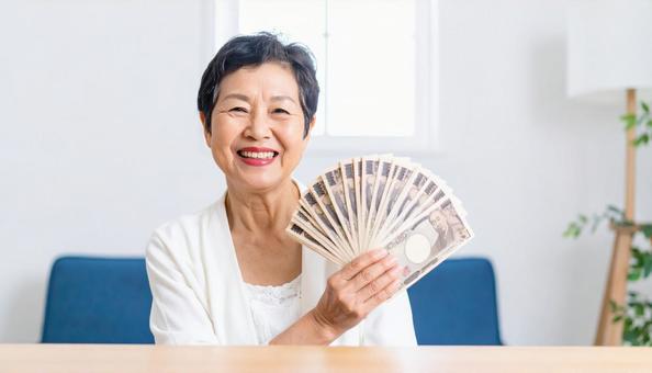 大金をゲットして喜ぶ年配の女性 大金をゲットして喜ぶ年配の女性の写真