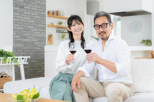 リビングでワインを飲むミドルの夫婦 リビングでワインを飲むミドルの夫婦 夫婦,家族,乾杯の写真素材