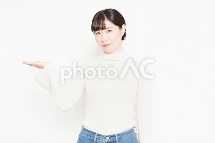 白背景の前で案内のポーズをする女性 紹介,おすすめ,案内の写真素材