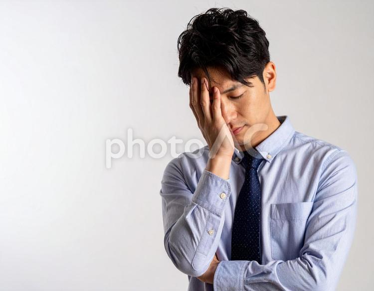 頭を抱えて頭痛に悩む男性 頭痛,病気,眩暈の写真素材