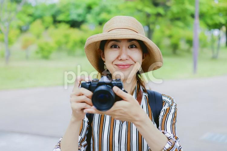 カメラを持って微笑む女性 カメラ,一眼レフ,一眼レフカメラの写真素材