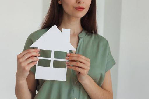 家の切り抜きを持った女性スタッフの手元 保険業,事務職,接客業の写真素材