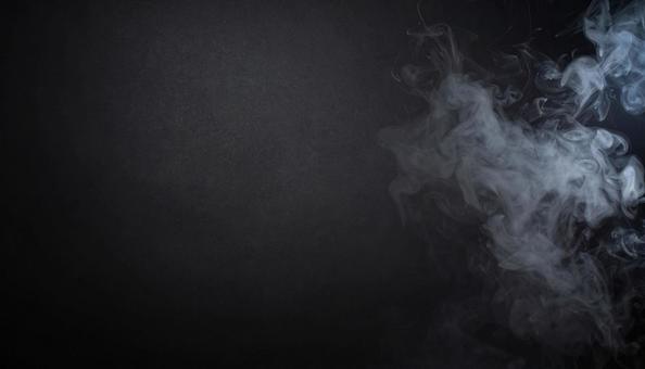 煙がわいている無地の黒背景の写真