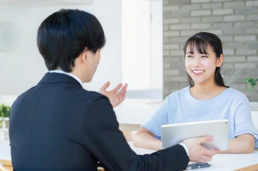 リビングで女性と商談をするビジネスマン リビングで女性と商談をするビジネスマンの写真