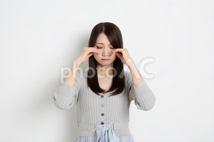 目を伏せて悲しんでいる若い女性 女性,女の子,女の写真素材