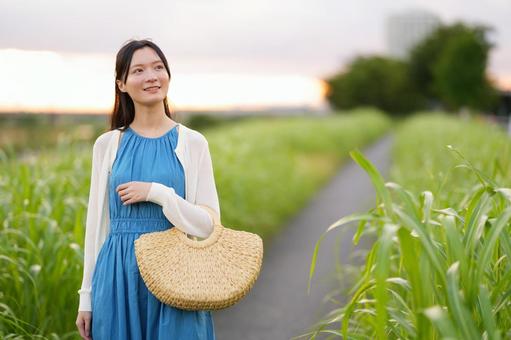 カゴバッグを微笑む散歩中の女性 女性,日本人,微笑むの写真素材