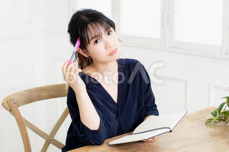 ノートとペンを持つ若い女性 女性,ビジネス,ノートの写真素材