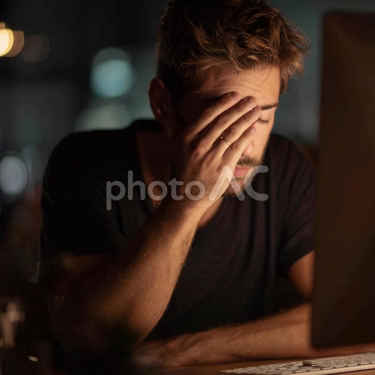 徹夜作業：デスクで目をこする男性 若者,男性,夜の写真素材