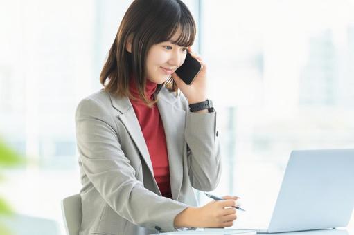 デスクワークをする女性・ビジネスウーマン 女性,スマホ,スマートフォンの写真素材