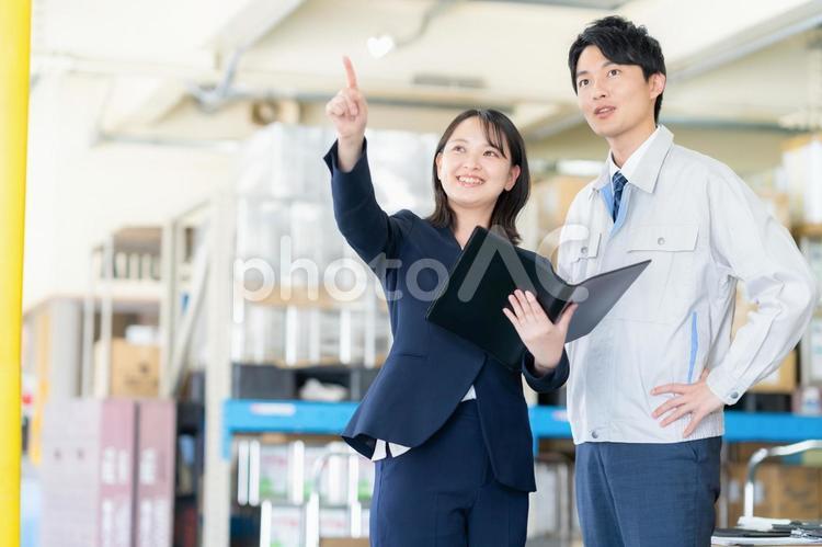 倉庫で会議をする男女のビジネスマン 倉庫,工場,打ち合わせの写真素材