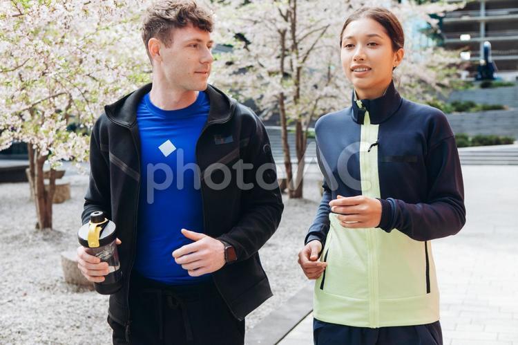 スポーツドリンクを持ってジョギングするカップル 男性,女性,スポーツドリンクの写真素材