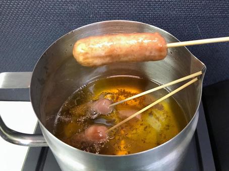 串刺しウィンナーをフライヤー米油で揚げる 串刺しウィンナーをフライヤー米油で揚げる フライ,油,フライヤーの写真素材