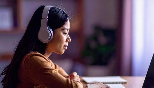 お気に入りの音楽を聴きながら勉強する女性の写真