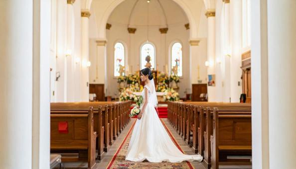 教会のバージンロードを歩く花嫁の横姿 教会のバージンロードを歩く花嫁の横姿の写真