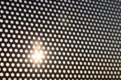 夕日とパンチングメタルのシルエット パンチングメタル,背景,テクスチャの写真素材