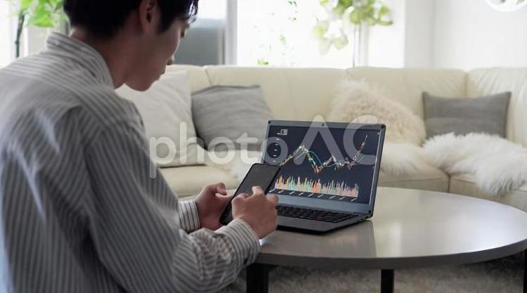 株価の上昇を見て喜ぶアジア人男性 株価,上昇,喜ぶの写真素材