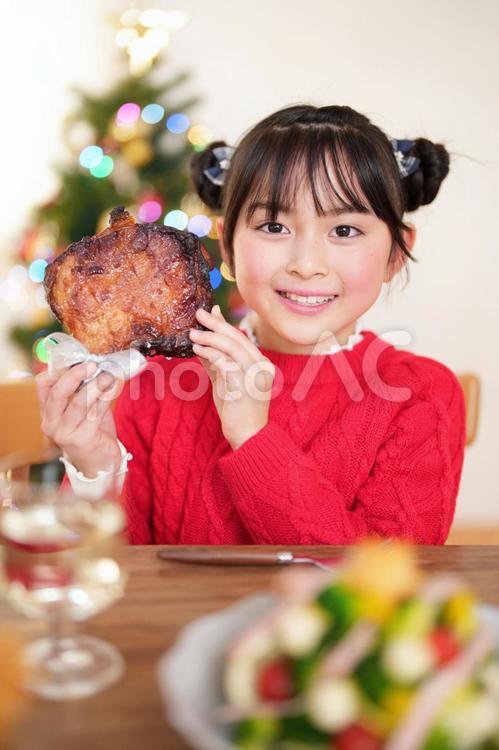 顔の横で笑顔でチキンを持つ女の子 女の子,チキン,持つの写真素材