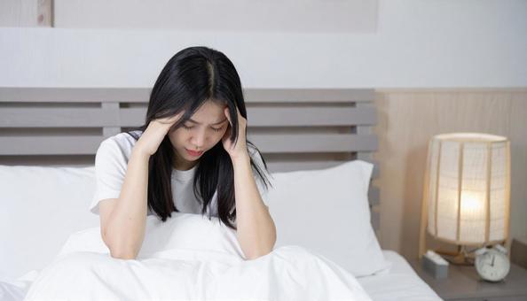 起床時に寝不足と疲労と体調不良の女性 起床時に寝不足と疲労と体調不良の女性の写真