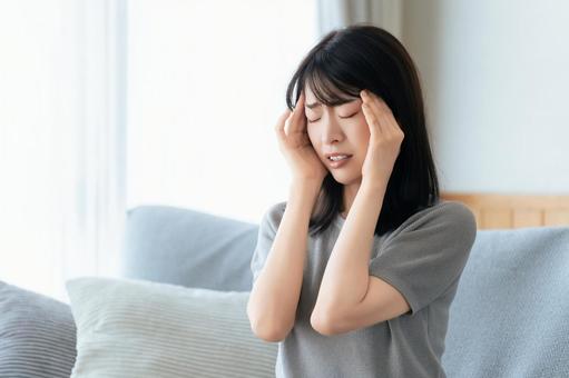 頭を押さえて悩む女性 頭を押さえて悩む女性 女性,悩む,困るの写真素材