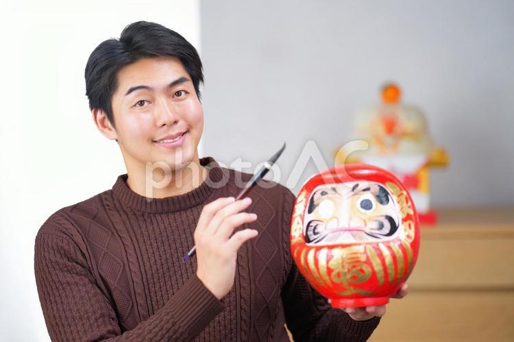 だるまと筆を持っている男性 男性,人物,正月の写真素材
