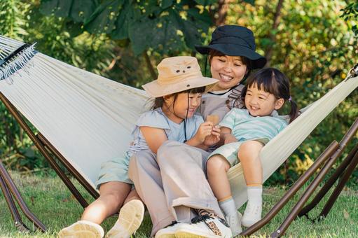 キャンプ場のハンモックで遊ぶ家族・親子 ハンモック,遊ぶ,家族の写真素材