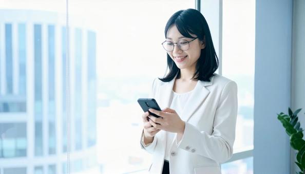スマホを確認するビジネス女性 スマホを確認するビジネス女性の写真
