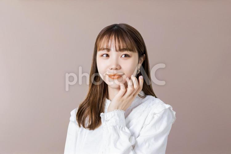 頬に手を当てる笑顔の女性 女性,人物,若いの写真素材