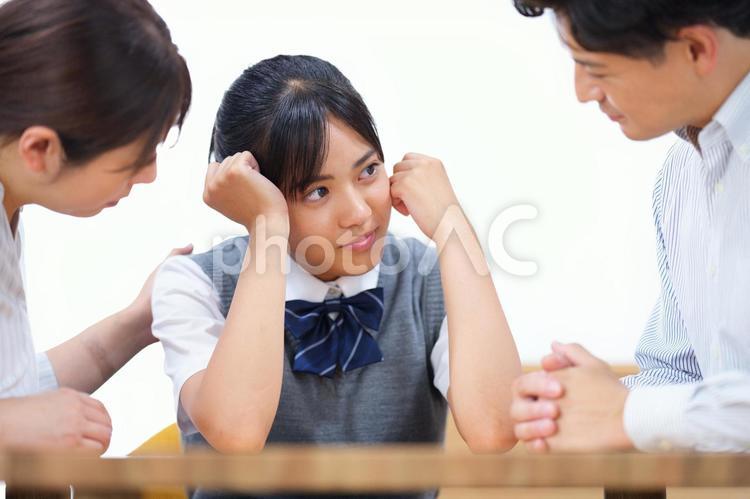 落ち込んでいる女子生徒の話を聞く両親 塾,人物,女の子の写真素材