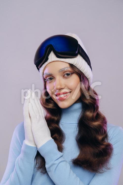 ゴーグルとニット帽をかぶった笑顔でカメラ目線の女性 冬,スポーツ,ウィンタースポーツの写真素材