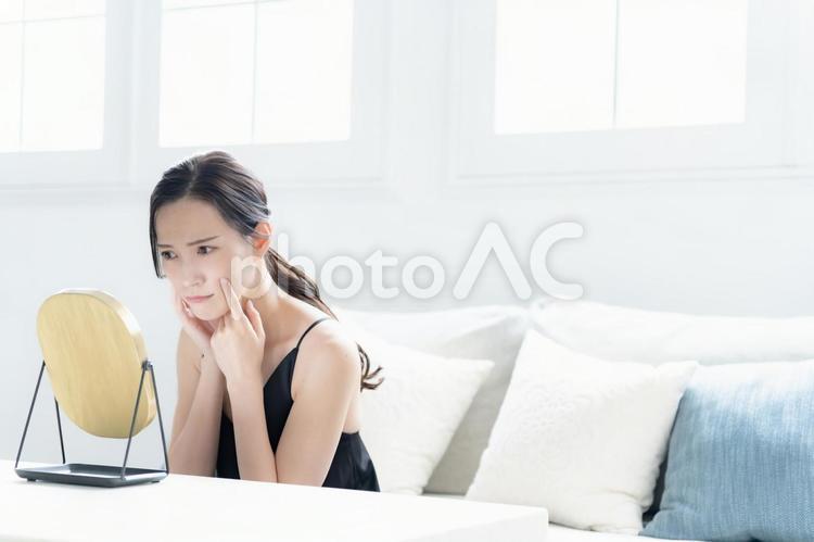 鏡を見て不満げな女性 悩む,自宅,準備の写真素材
