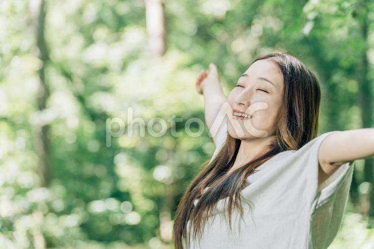 避暑地で深呼吸する日本人女性（森林浴） 森林浴,深呼吸,気持ちいいの写真素材
