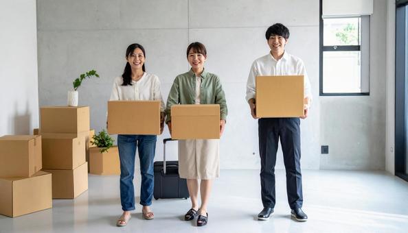 引っ越しで荷物を運ぶ男女 引っ越しで荷物を運ぶ男女の写真