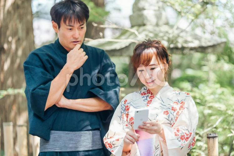スマホを持つ浴衣姿の男女 浴衣,アプリ,カップルの写真素材