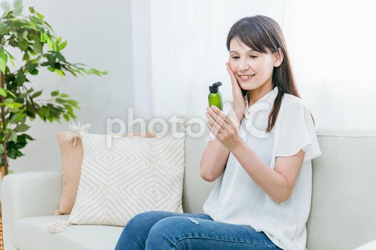 スキンケアするミドル世代の女性（笑顔） スキンケア,アンチエイジング,化粧水の写真素材