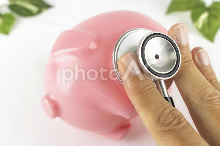 豚の貯金箱と手と聴診器。家計のイメージ 貯金箱,聴診器,金融の写真素材